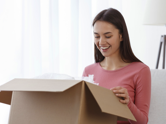 Young woman smiling and opening a box full of treats