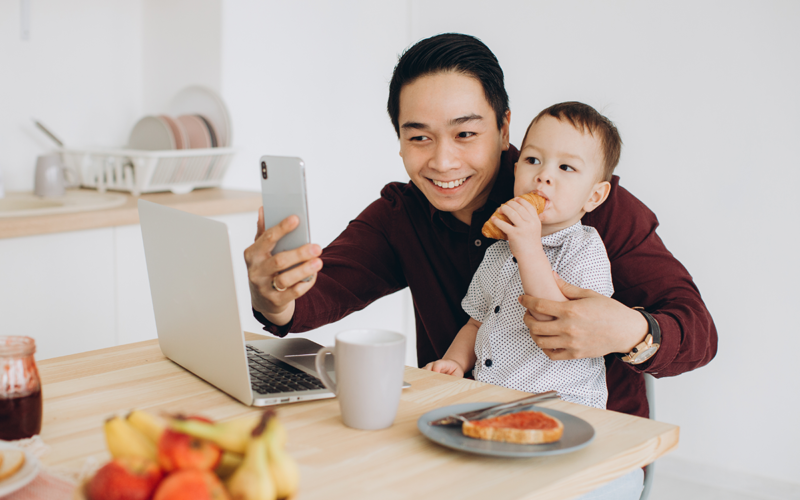 Operations Manager working from home with his son while having breakfast together