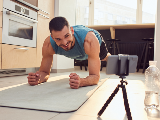 male holding a plank in living room over a virtual fitness session