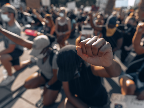 people standing with their fists high in a black lives matter march