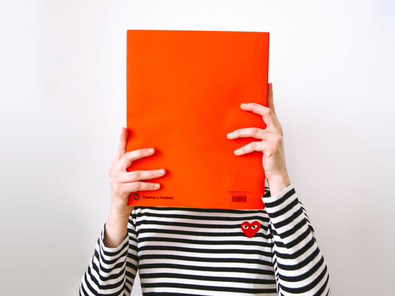 An employee hiding behind a bright orange book in an introvert-friendly space