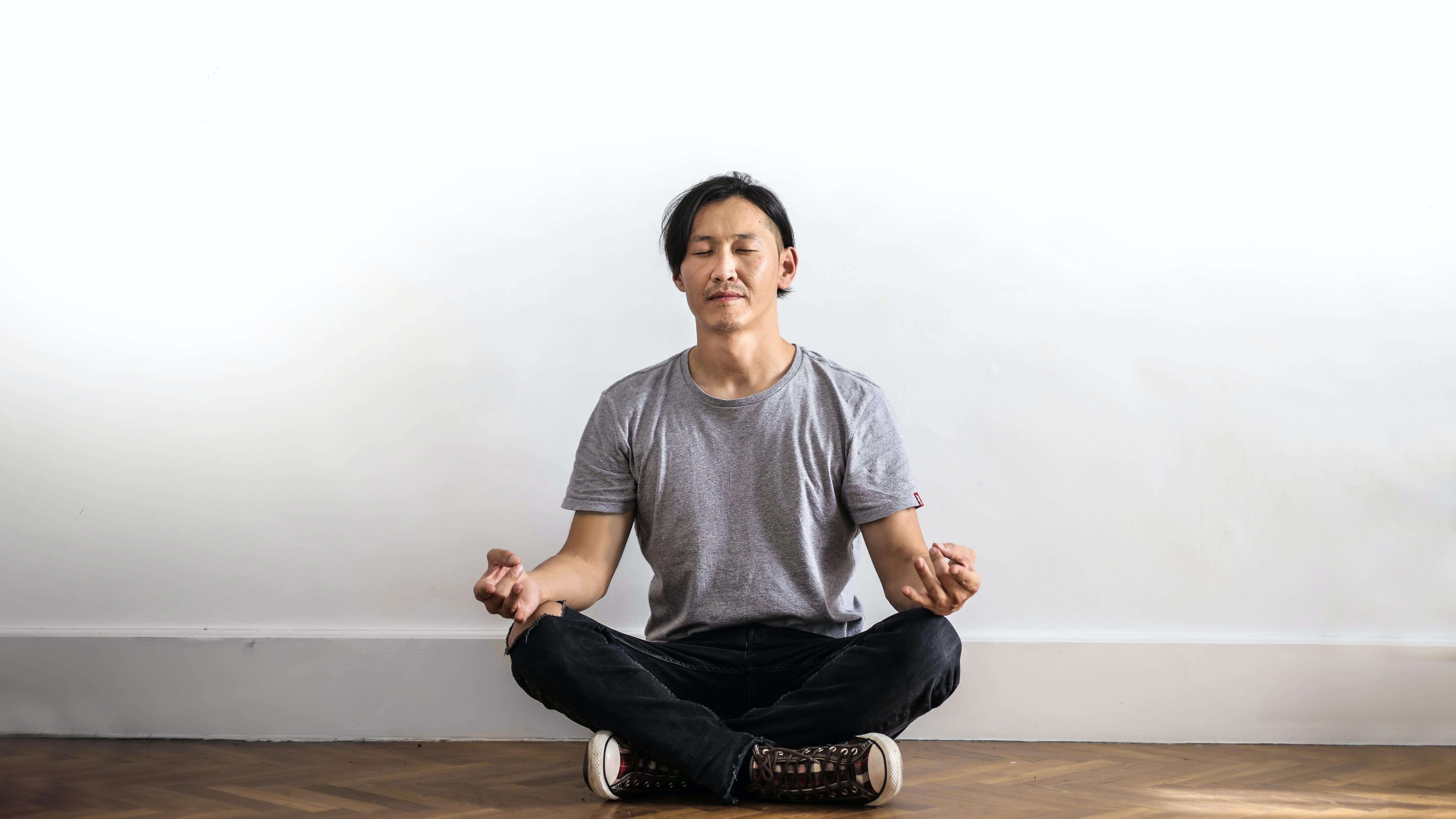 Person meditating, while sitting on the floor