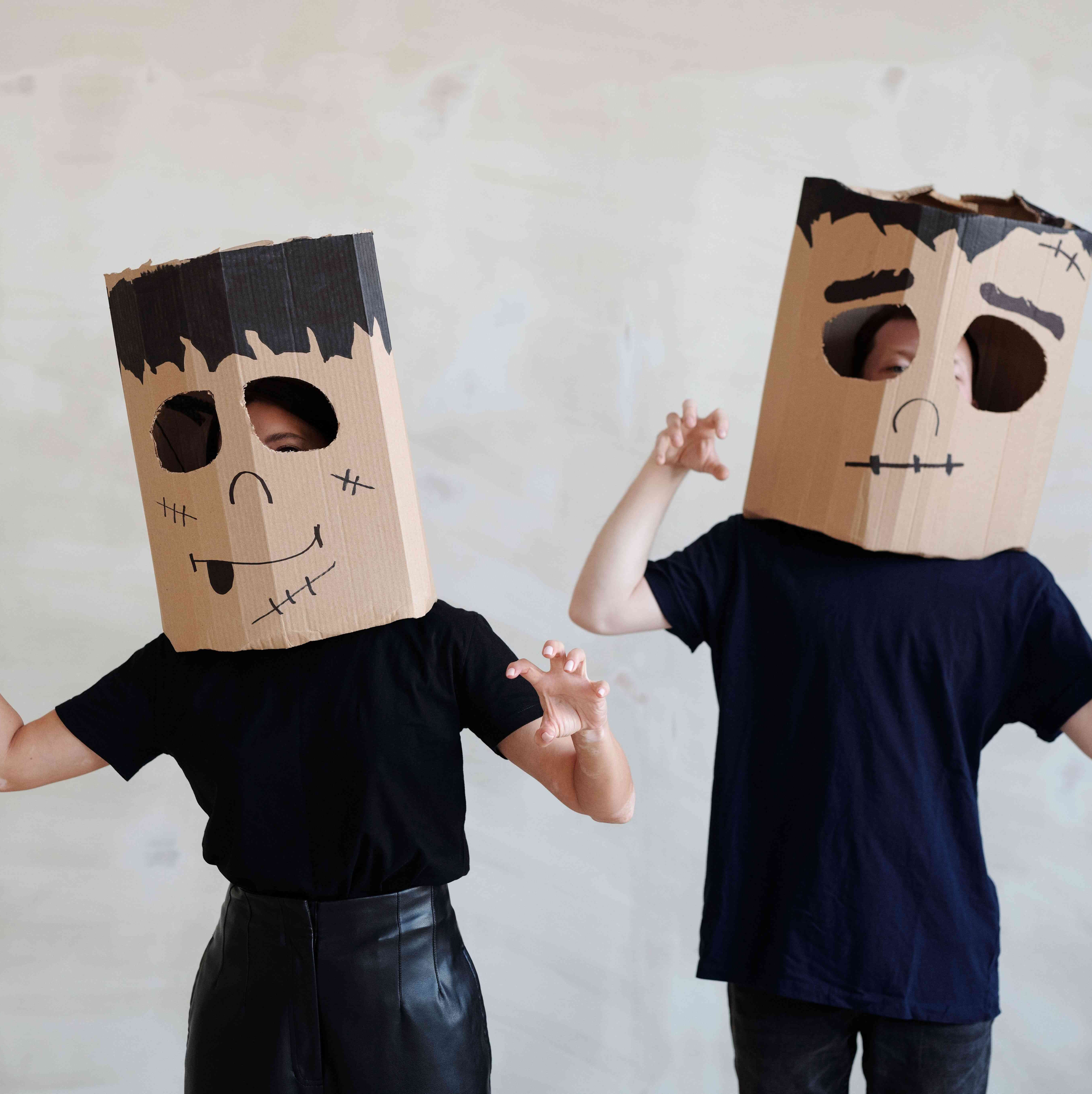 Two persons with cardboard boxes on their heads dressed as Frankensteins