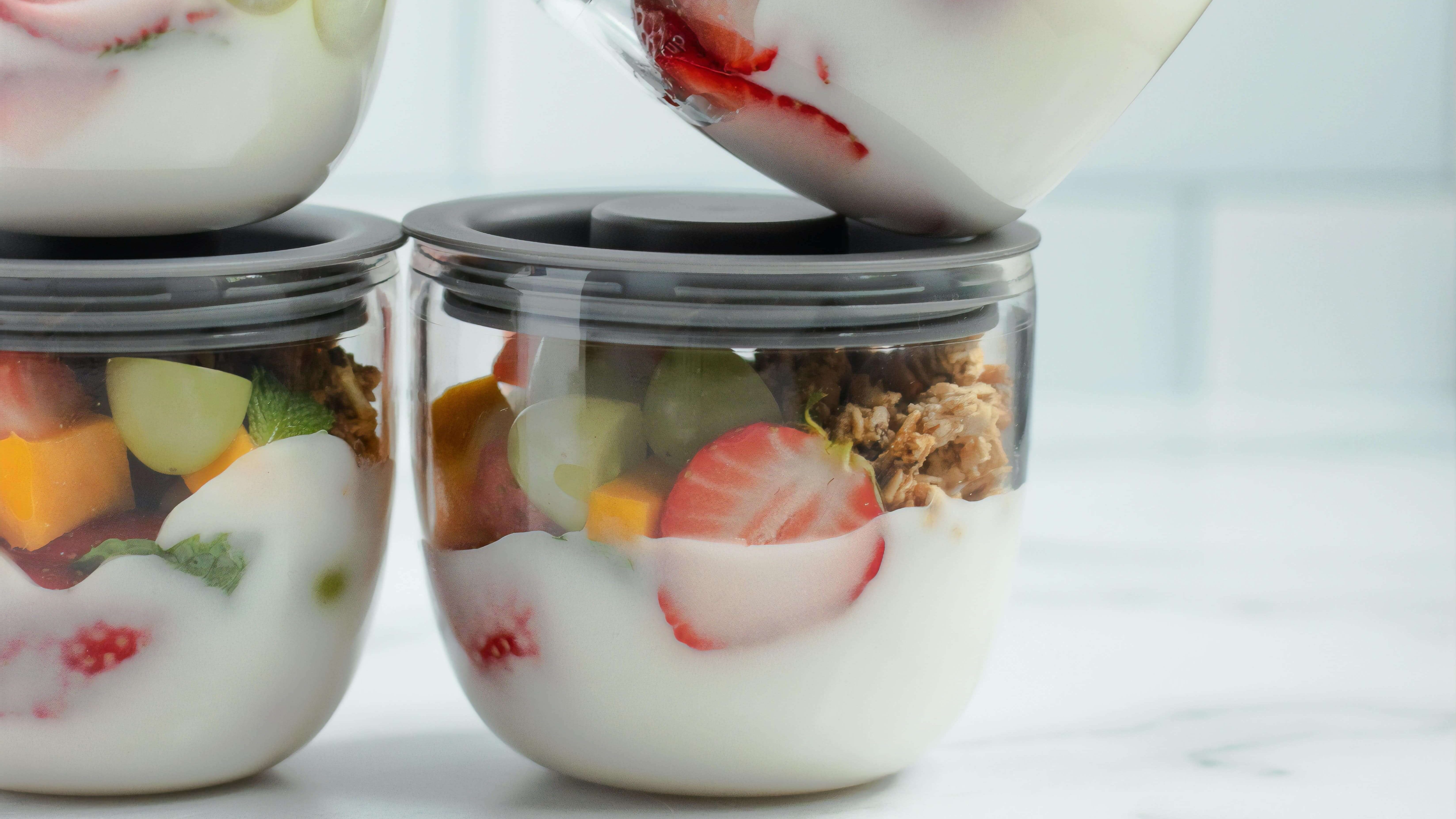 Several bowls of healthy snack with yogurt and fruits