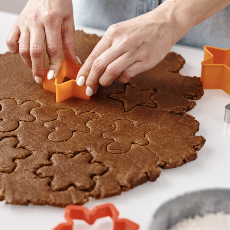 A person cutting Christmas cookies