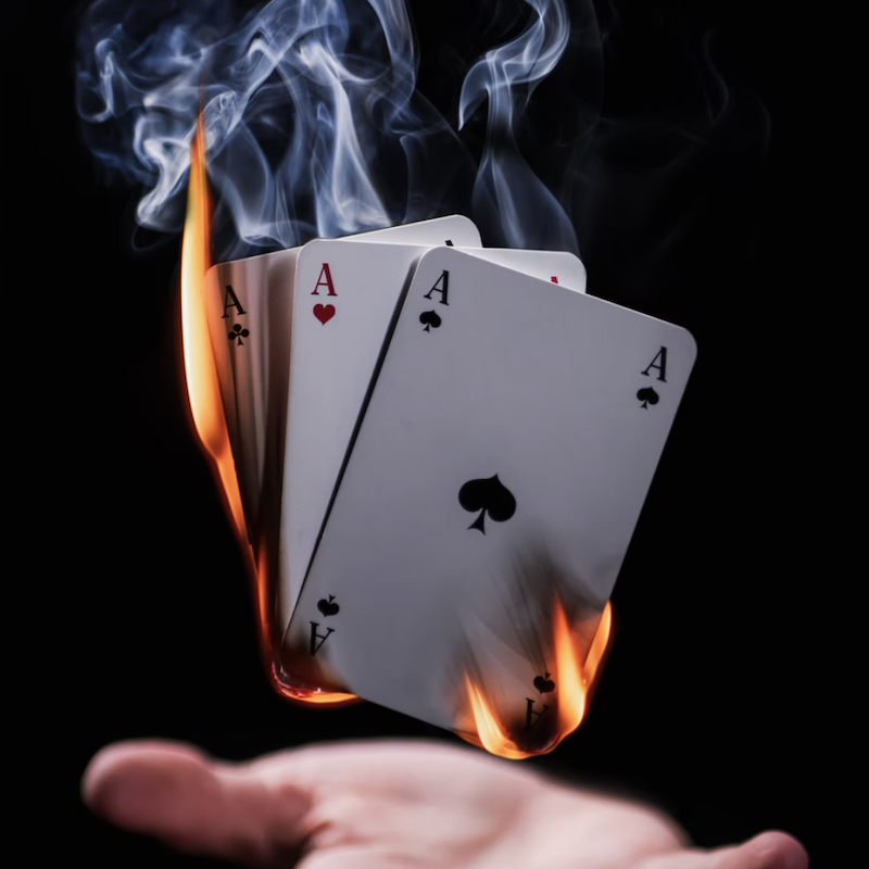 A person showing focus with burning cards