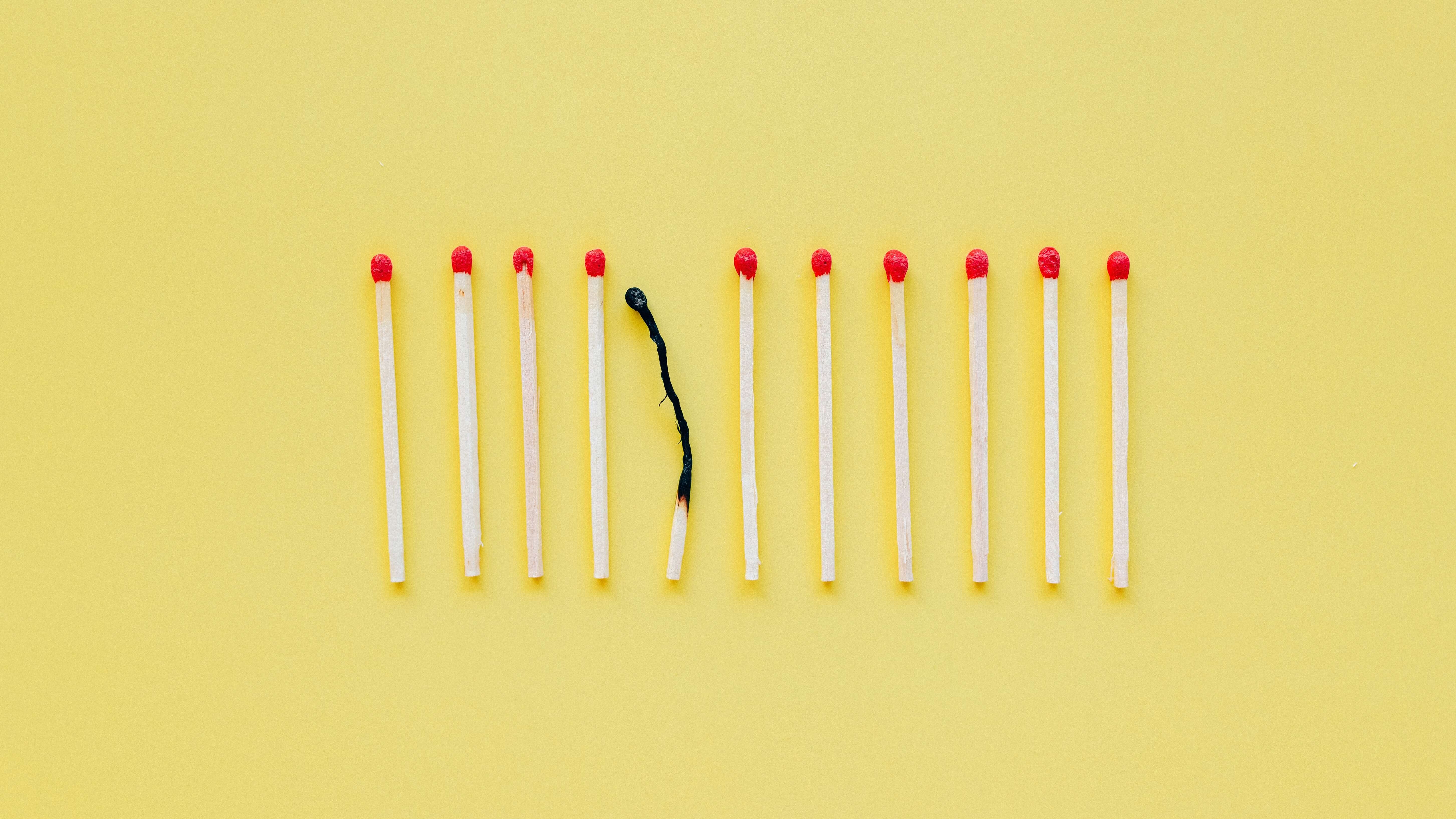 A single burnt match in a group of matches