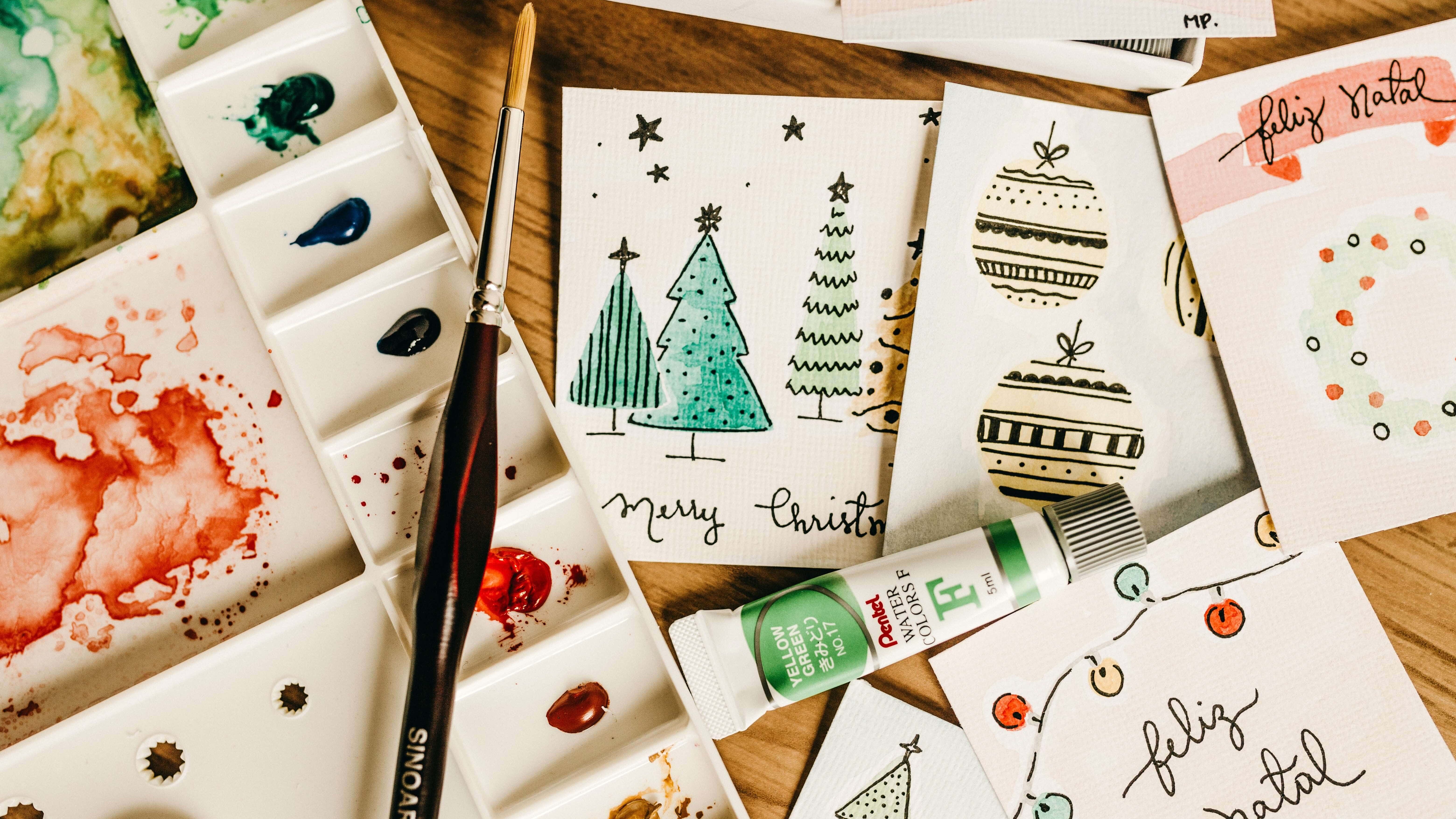Holiday cards and paints on the table