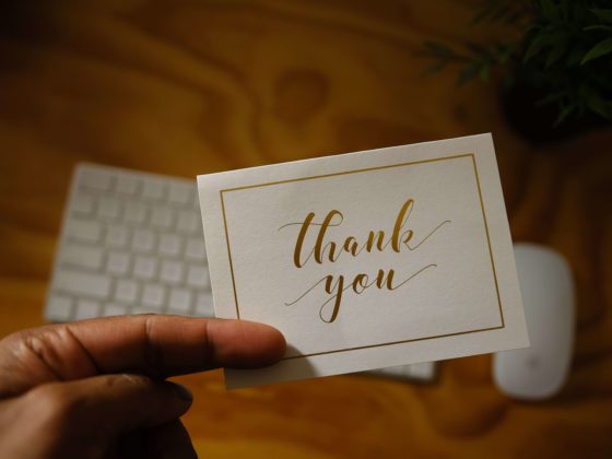 Employee holding a card that says thank you