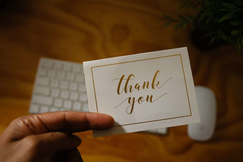 Employee holding a card that says thank you