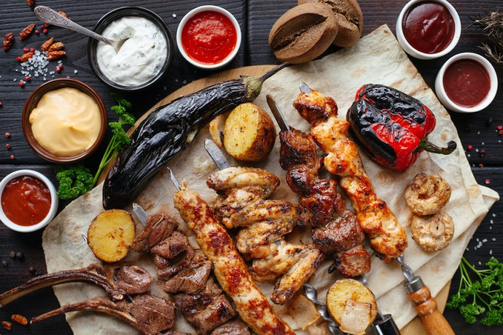 BBQ picnic plate on a table, with various kinds of grilled meat and vegetables