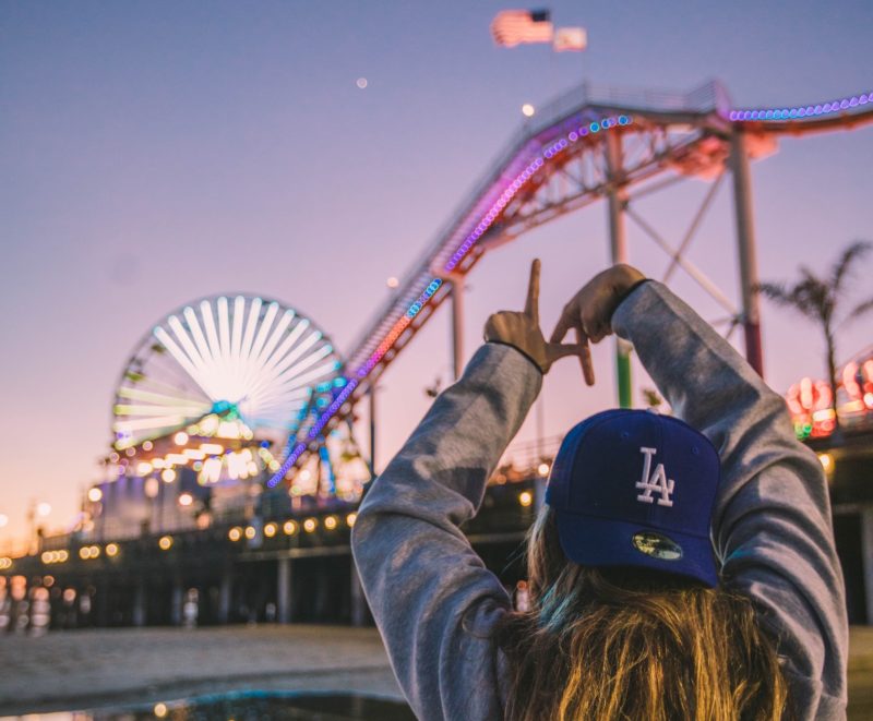 A person showing letters LA with their hands in the Los Angeles amusement park
