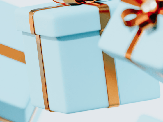 blue gift boxes with gold ribbon on a light coloured background
