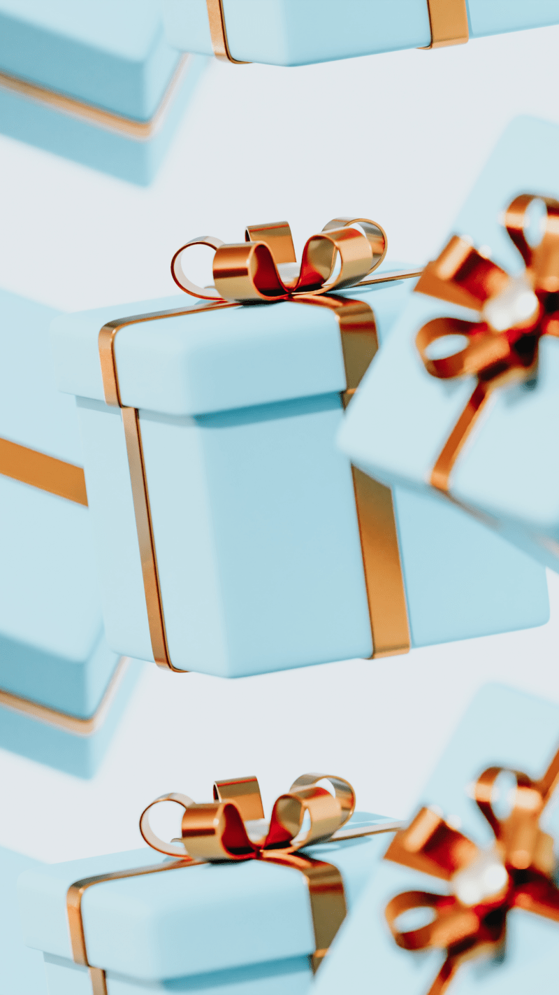 blue gift boxes with gold ribbon on a light coloured background