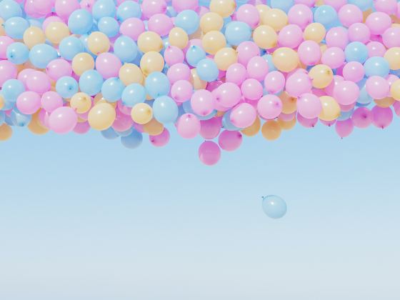 Pink, yellow, and blue balloons floating in the sky.