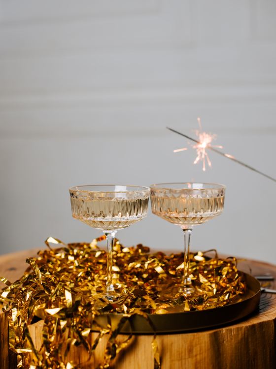 Image of champagne and sparklers with gold tinsel.